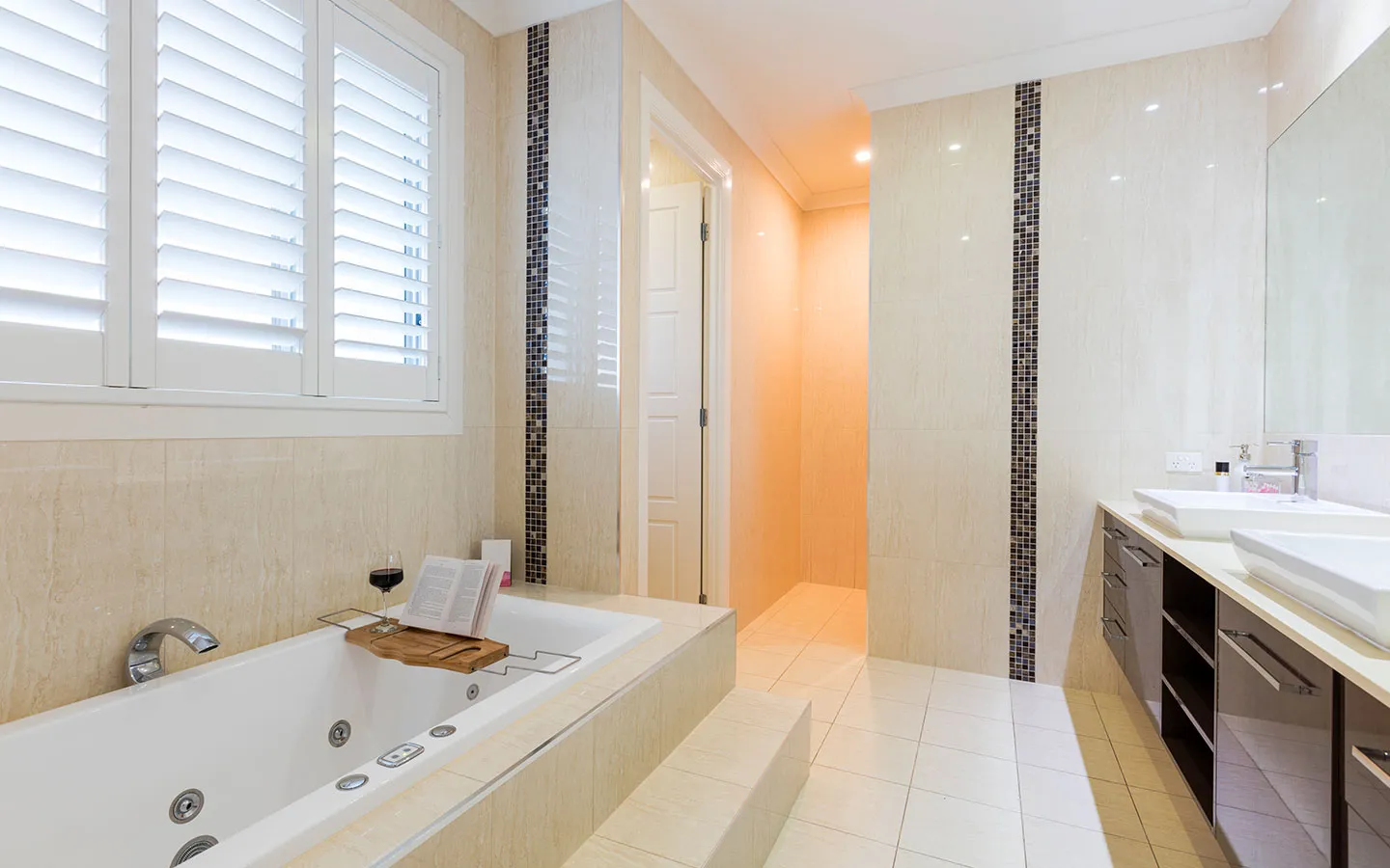 Bathroom with a white roller blind over a window beside a freestanding bath