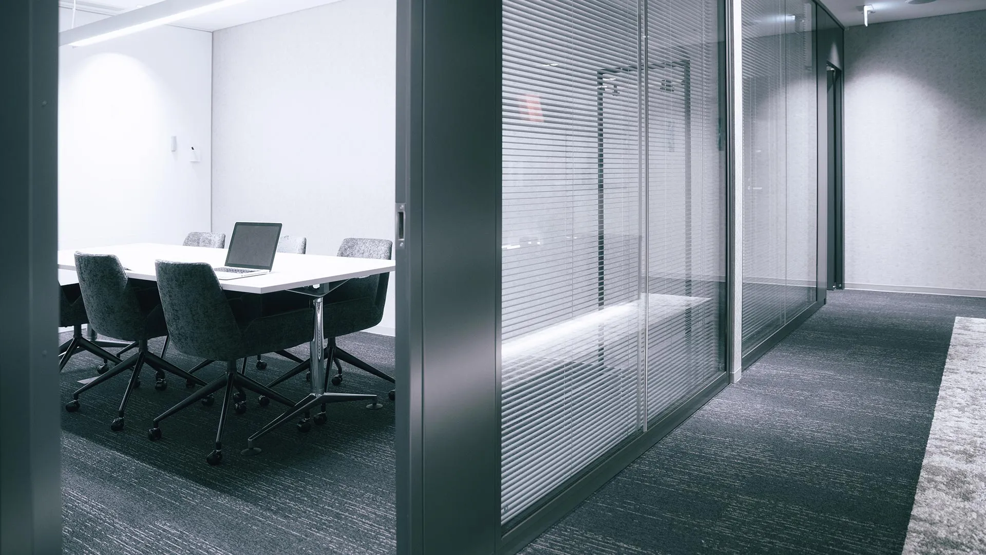 Glass-walled meeting room fitted with venetian blinds
